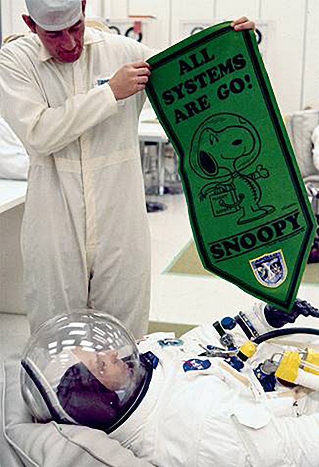 In this May 1969 image obtained from NASA, astronaut Tom Stafford, wearing his spacesuit, is being shown a pennant bearing the Peanuts comic book character Snoopy at the Kennedy Space Center in Florida. PHOTO: AFP