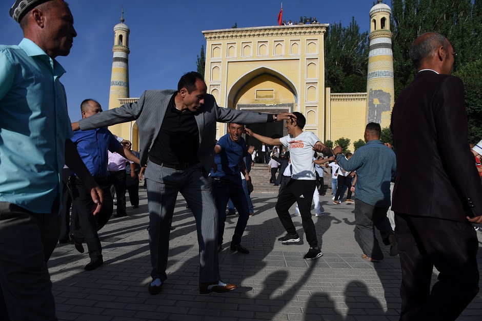 Uighur men dance after Eid al-Fitr prayers, marking the end of Ramadan, at the Id Kah mosque in Kashgar, in China's western Xinjiang region early on June 5, 2019. - While Muslims around the world celebrated the end of Ramadan with early morning prayers and festivities this week, the recent destruction of dozens of mosques in Xinjiang highlights the increasing 