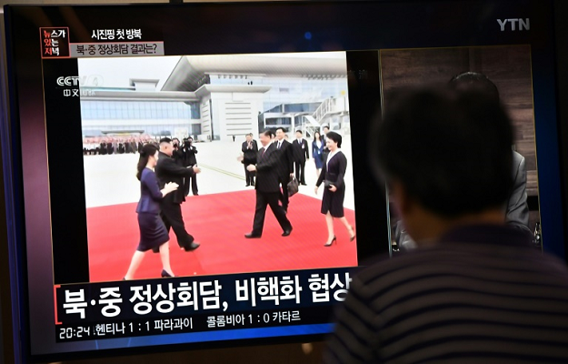 A man in Seoul, South Korea, watches television coverage of North Korean leader Kim Jong Un welcoming Chinese President Xi Jinping who became the first president of China to visit the North in 14 years. PHOTO: AFP