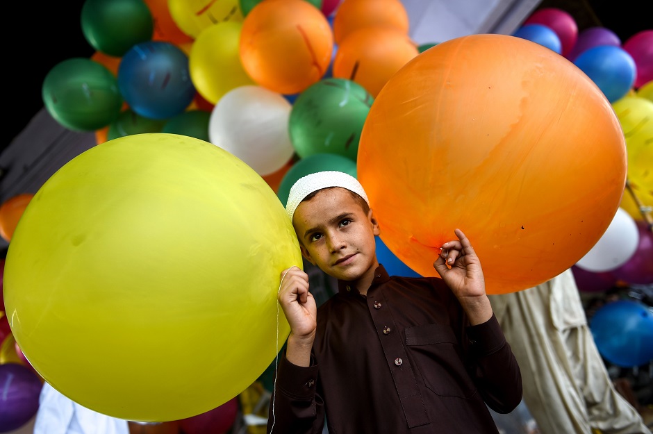 A young boy holds balloons after offering prayers during Eidul Fitr in Karachi. PHOTO: AFP