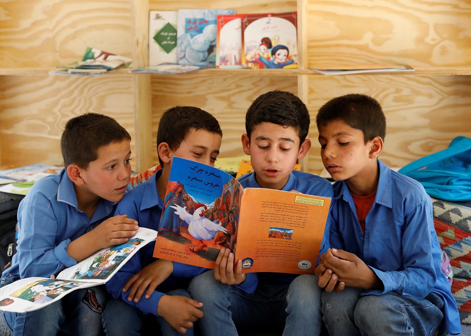 Afghan boys read books inside a mobile library bus in Kabul, Afghanistan. PHOTO: Reuters.