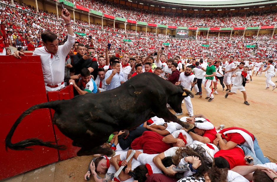A wild cow jumps over revellers after the last bull run of the San Fermin festival in Pamplona. PHOTO: Reuters