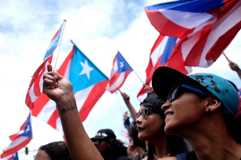 Demonstratorsâ wave flags as they participate in a march the day after the governor of Puerto Rico, Ricardo Rossello resigned from his charge in San Juan. PHOTO: AFP