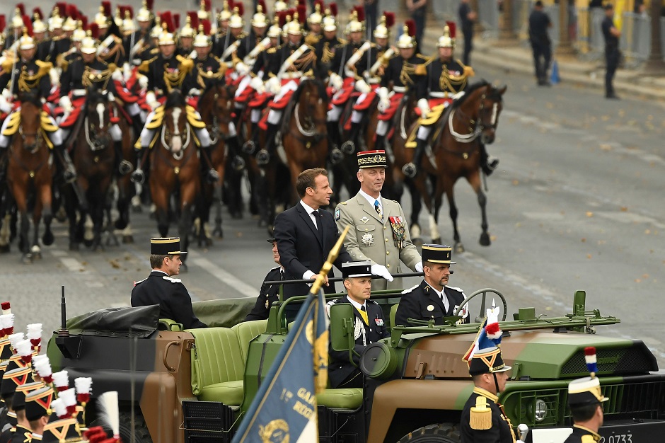 France's President Emmanuel Macron (C-L) stands in an Acmat VLRA vehicle next to French Armies Chief Staff General Francois Lecointre as they review troops before the start of the Bastille Day military parade down the Champs-Elysees avenue in Paris. PHOTO: Reuters