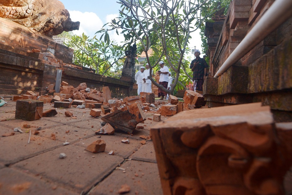 Balinese Hindu men look at a Hindu temple damaged following an earthquake in Denpasar, Bali, Indonesia. PHOTO: Reuters