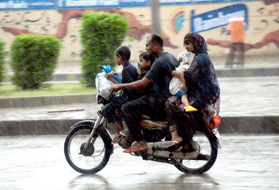 A photo of a motorcyclist with his family members passing through heavy rain in the city. PHOTO: APP