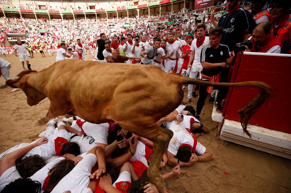 A wild cow leaps over revellers during the running of the bulls. PHOTO: Reuters