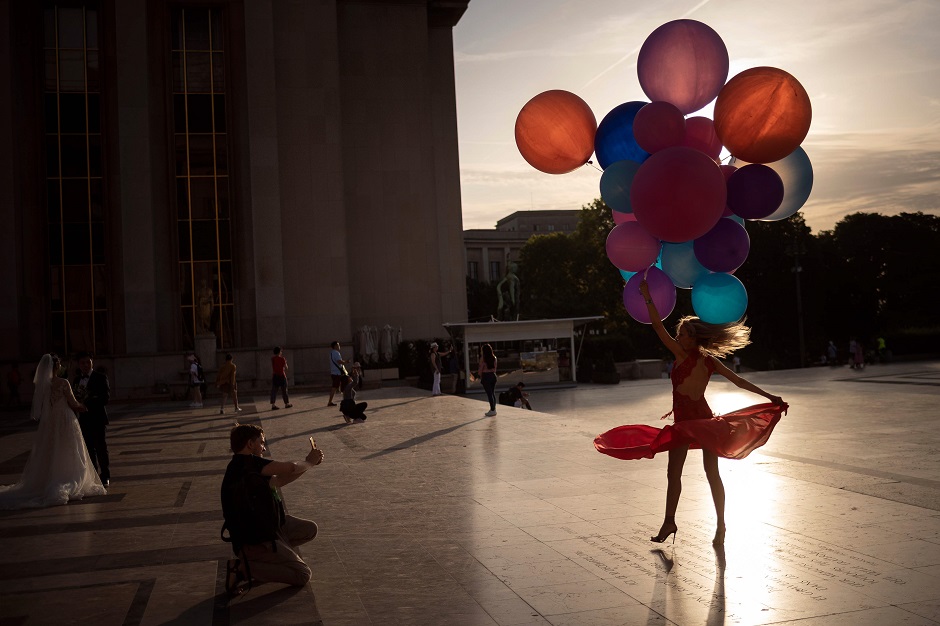 A woman poses with balloons at the Trocadero in Paris as a heat wave hits the French capital. PHOTO: AFP
