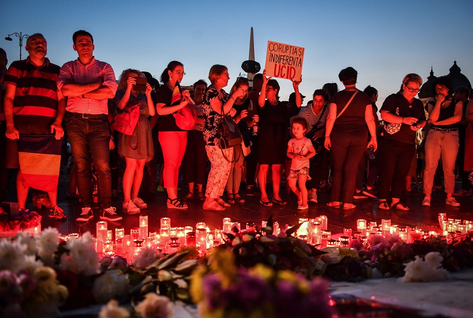 People light candles in front of the Romanian Ministry of Interior in Bucharest to commemorate Alexandra, the 15-year-old girl who has being murdered after she telephoned three times to report her own kidnapping. PHOTO: AFP