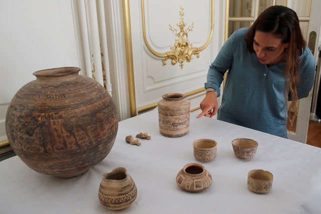 archaeologist aurore didier points to some artifacts amongst the 445 artifacts from the 2nd and 3rd millennium bc which were seized by french customs between 2006 and 2007 before being returned by french authorities to pakistan during a ceremony at the embassy of pakistan in paris france july 2 2019 photo reuters