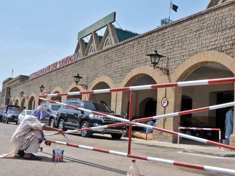 a worker paints a barrier at the rawalpindi railway station ahead of pm s visit photo inp