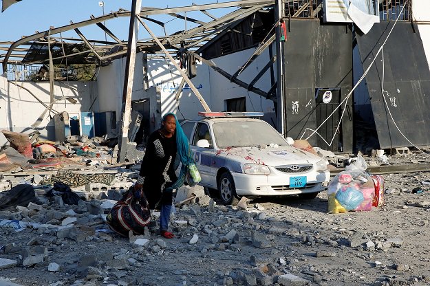 a migrant picks up her belongings from among rubble at a detention centre for mainly african migrants that was hit by an airstrike in the tajoura suburb of the libyan capital of tripoli photo reuters