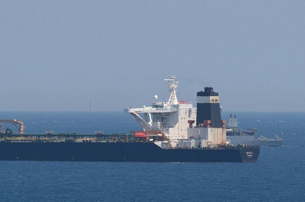 A British Royal Navy ship (back R) patrols near supertanker Grace 1 suspected of carrying crude oil to Syria in violation of EU sanctions after it was detained off the coast of Gibraltar on July 4, 2019. PHOTO: AFP