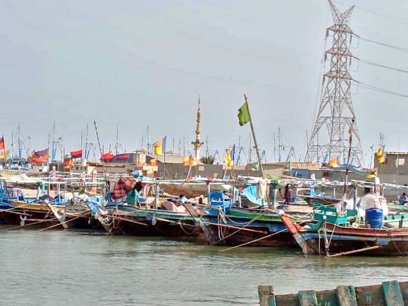 boats stand ashore at a fish harbour along the karachi s 129 kilometre long coastline as fishermen remain restricted from fishing photo express