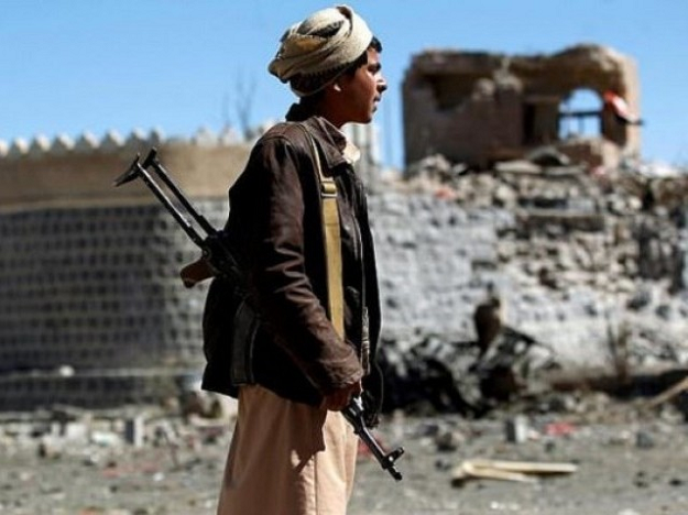 an armed yemeni inspects the damage following a reported saudi led coalition air strike on south sanaa photo afp