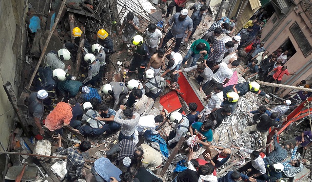 rescue workers and residents search for survivors at the site of a collapsed building photo reuters