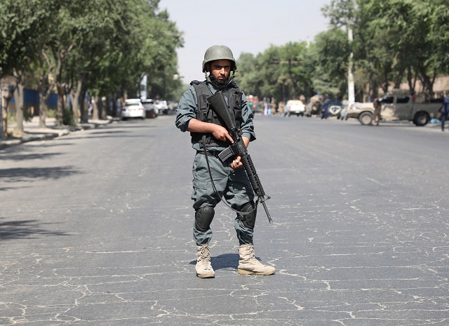 an afghan policeman keeps watch at the site of a blast near kabul university in kabul photo reuters