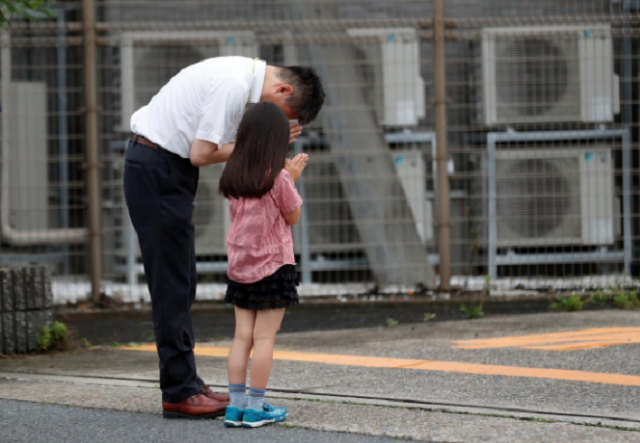 father and daughter mourning the loss of victims in the japan attack photo reuters