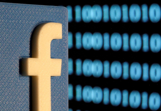 a 3 d printed facebook logo is seen in front of displayed binary code in this illustration picture june 18 2019 photo reuters