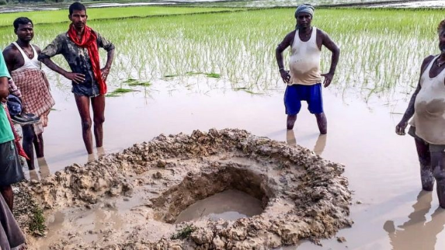 villagers and farmers gather around the crater formed when a suspected meteorite crashed into a rice paddy in madhubani district in india 039 s bihar state photo afp