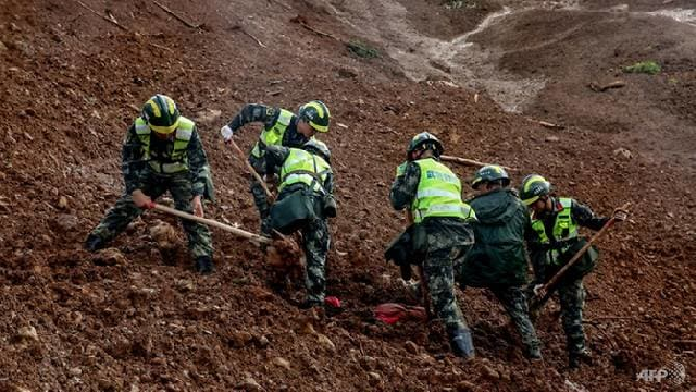 rescuers search through a landslide in a village in guizhou province photo afp