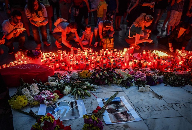 people light candles at a makeshift memorial site in front of the romanian ministry of interior in bucharest photo afp