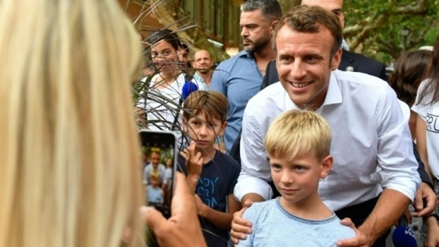 french president emmanuel macron c on saturday posed for pictures in bormes les mimosas near the fort of bregancon where he will host his russian counterpart vladimir putin in august photo afp