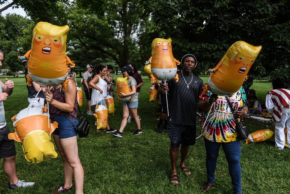 People blow up baby Trump Balloons during the 4th of July festivities. :AFP
