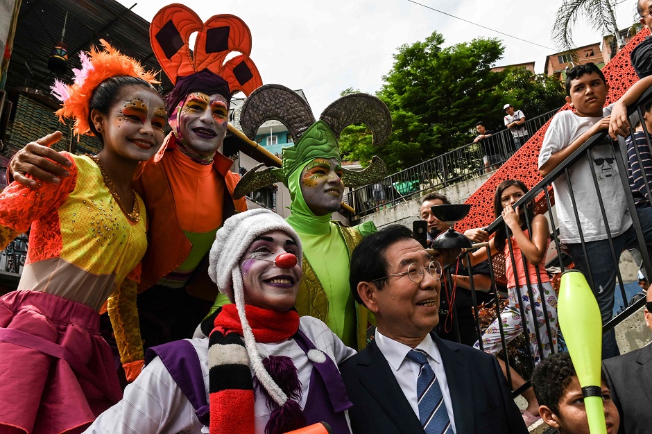  Seoul's Mayor, Park Won-soon (bottom-R), from Korea, poses for photos with local artists at the Comuna 13 Neighborhood during the World Cities Summit Mayor Forum in Medellin, Colombia:AFP 