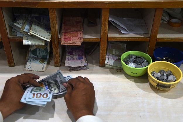 In this picture, a foreign currency dealer counts US dollar notes at a shop in Karachi. PHOTO: AFP