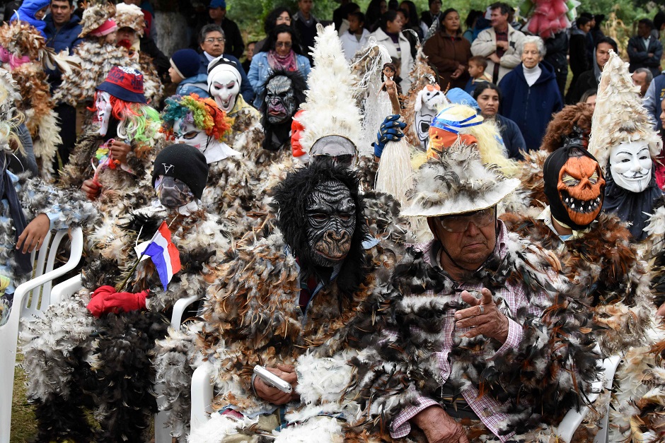 Indigenous people wearing masks and dressed in costumes made of hen feathers, pay tribute to Saint Francis Solanus, and thank him for his favours, during the 