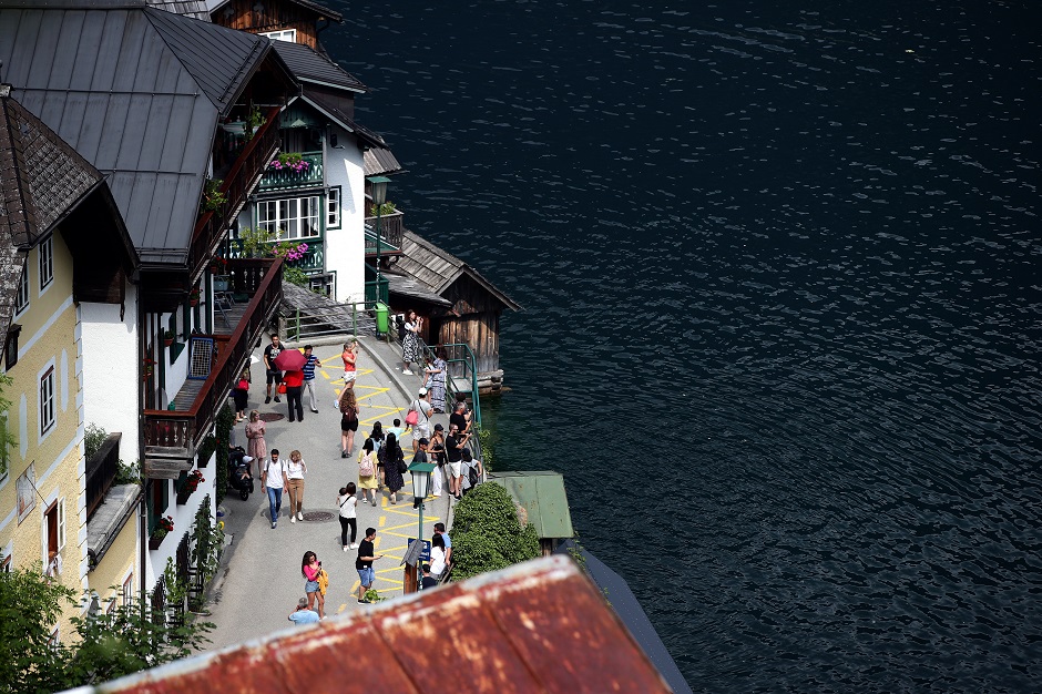 Tourists stroll near Hallstaettersee lake in the alpine village of Hallstatt, Austria. PHOTO: Reuters