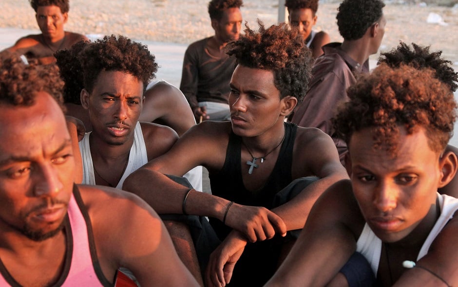 Rescued migrants sit on the coast of Khoms, some 100 kilometres (60 miles) from the Libyan capital Tripoli. PHOTO: AFP