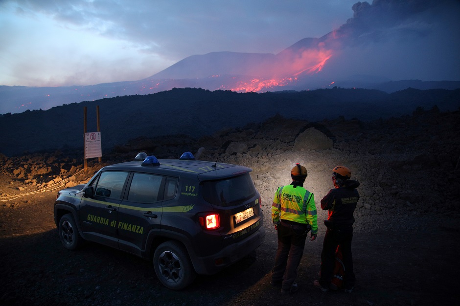 Members of the Guardia di Finanza alpine rescue look on as Mount Etna, Europe's highest and most active volcano, erupts in Sicily, Italy. PHOTO: Reuters