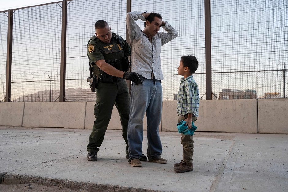 Jose, 27, with his son Jos Daniel, 6, is searched by US Customs and Border Protection Agent Frank Pino, in El Paso, Texas. PHOTO: AFP