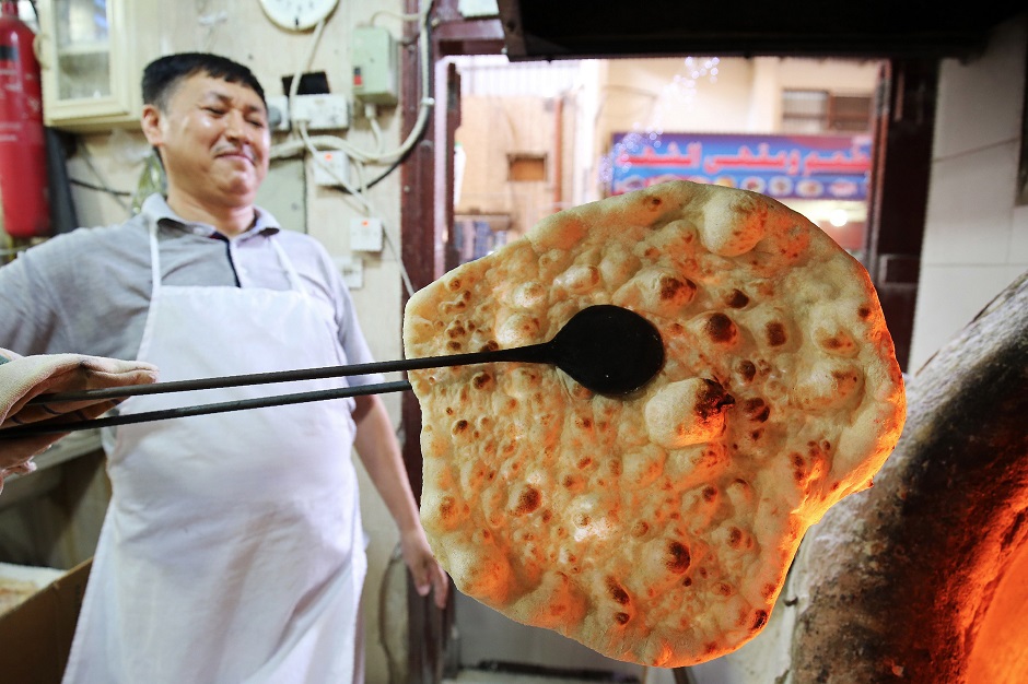 7.A baker bakes Iranian bread - known as taftoon - at a bakery in Kuwait City. Iranian bread has for decades been a staple of Kuwaiti breakfast, lunch and dinner tables. PHOTO: AFP