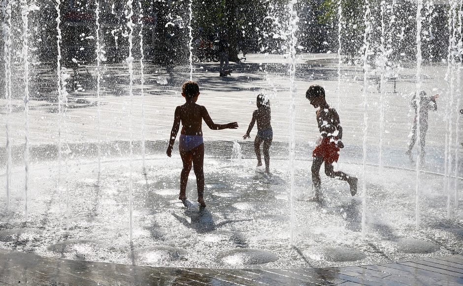 Kids cool off during hot summer weather in a public fountain on the Sechselaeutenplatz square in Zurich, Switzerland. PHOTO: Reuters