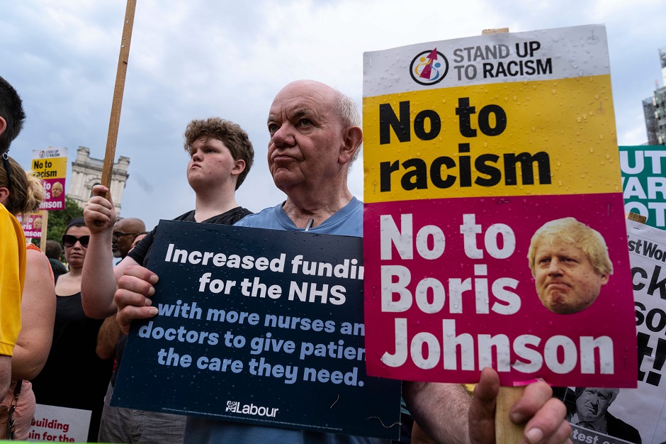 Supporters hold placards as Britain's opposition Labour party leader Jeremy Corbyn addresses a rally calling for a General Election now, in Parliament Square, central London. PHOTO: AFP