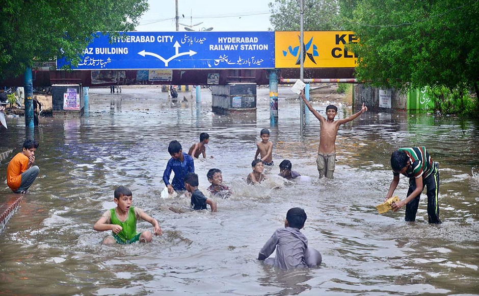 Children playing in the rain at the railway underpass in Hyderabad. PHOTO: APP
