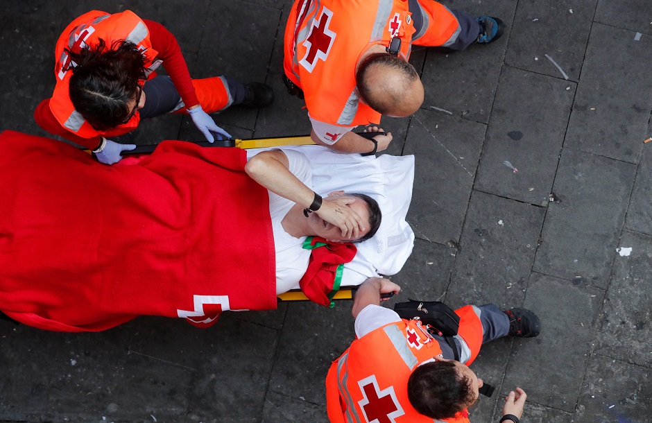 A reveller is helped by medical staff during the running of the bulls at the San Fermin festival. PHOTO: Reuters.
