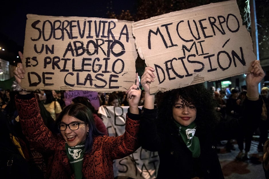 Activists hold signs in favour of free abortion abortion during a demonstration in Santiago. PHOTO: AFP