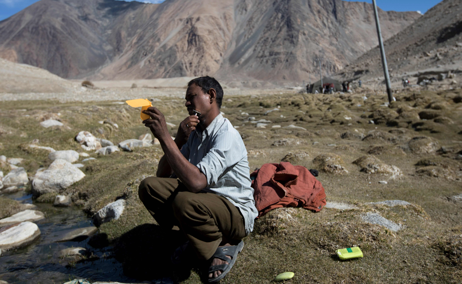 Raj Shekhar, 33, a road maintenance worker from India's low-lying eastern Jharkhand state, shaves on his day off at his campsite near Tangtse village in northern India's Ladakh region. Photo: AFP