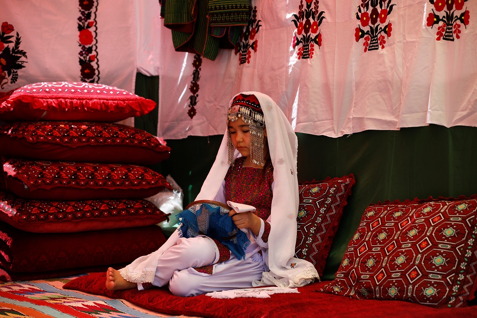 A Hazara girl with traditional jewellery does embroidery at a cultural stall during the Hazara Culture Day. PHOTO: Reuters