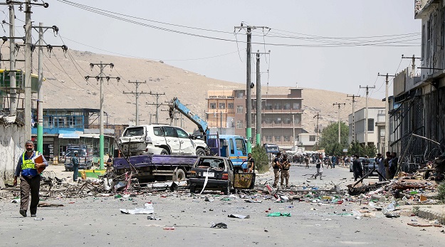 Afghan security personnel remove a damage vehicle at the site, following a suicide bombing in Kabul. PHOTO: AFP