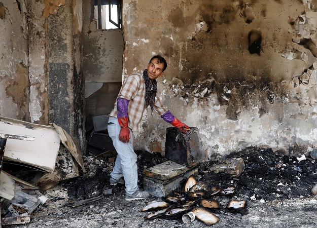 An Afghan man shows burnt iteams of his house after Sunday's attack in Kabul, Afghanistan. PHOTO: REUTERS 
