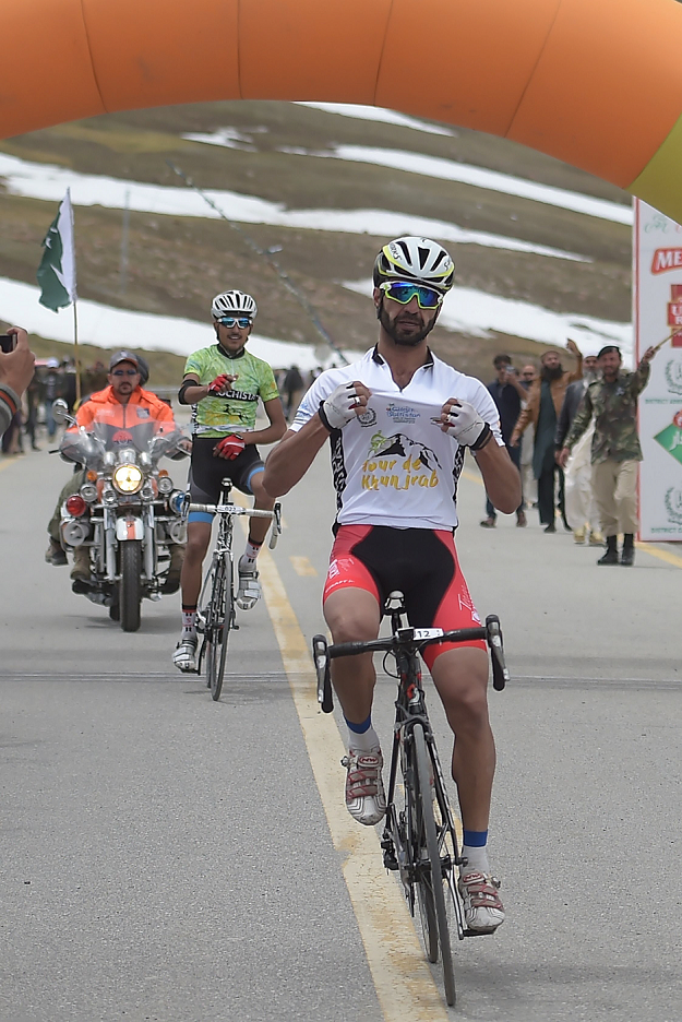 In this picture taken on June 30, 2019, Pakistani cyclist Najeeb Ullah (C) celebrates as he crosses the finish line during the Tour de Khunjerab, one of the world's highest altitude cycling competitions at the Pakistan-China Khunjerab border. PHOTO: AFP