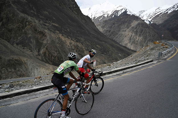 In this picture taken on June 30, 2019, Pakistani cyclists Najeeb Ullah (R) and Hanzala (L) compete during the Tour de Khunjerab, one of the world's highest altitude cycling competitions, at the Pakistan-China Khunjerab border. PHOTO: AFP