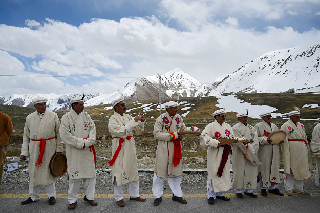 In this picture taken on June 30, 2019, Pakistani musicians perform as they cheer cyclists during the Tour de Khunjerab, one of the world's highest altitude cycling competitions, at the Pakistan-China Khunjerab border. PHOTO: AFP