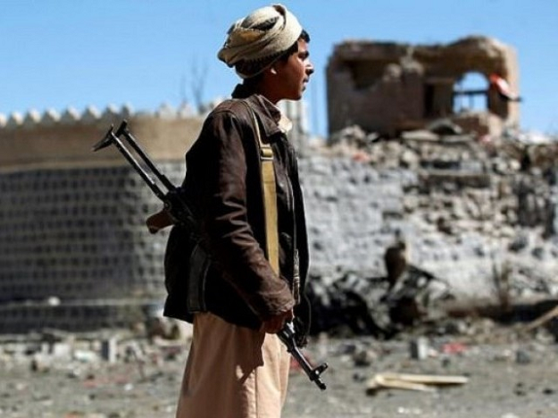 An armed Yemeni inspects the damage following a reported Saudi-led coalition air strike on south Sanaa. PHOTO: AFP