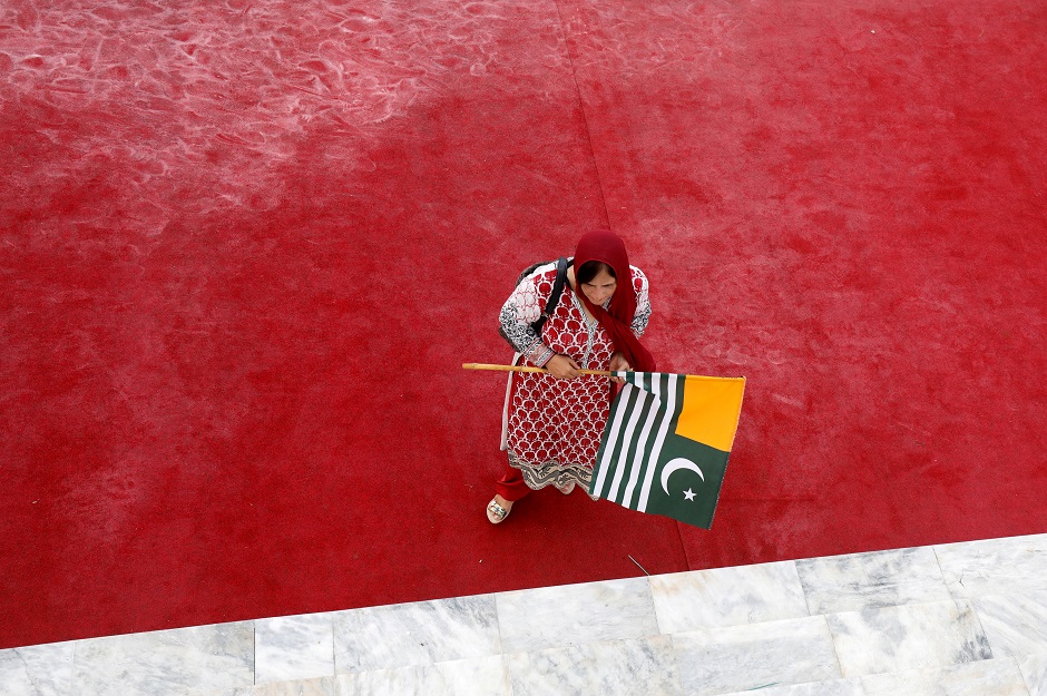 A woman walks with Kashmir's flag to express solidarity with the people of Kashmir, at the Mausoleum of Muhammad Ali Jinnah. (Photo: Akhtar Soomro / REUTERS)